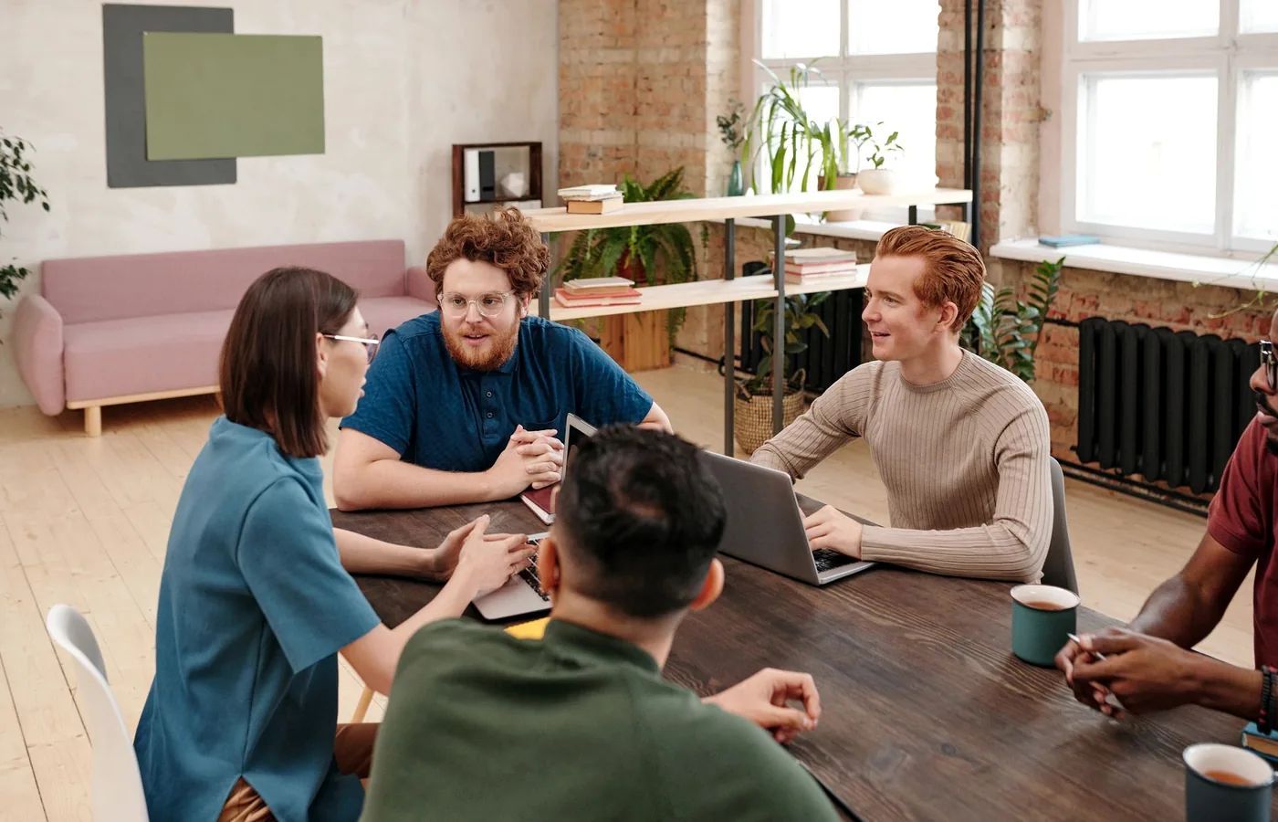 Diverse team engaged in a professional meeting with laptops