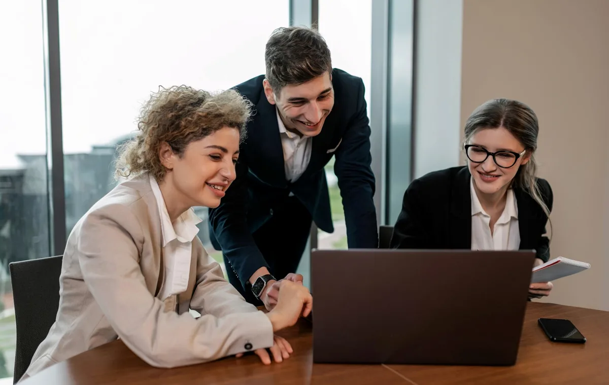 Professionals reviewing work together on a laptop in an office
