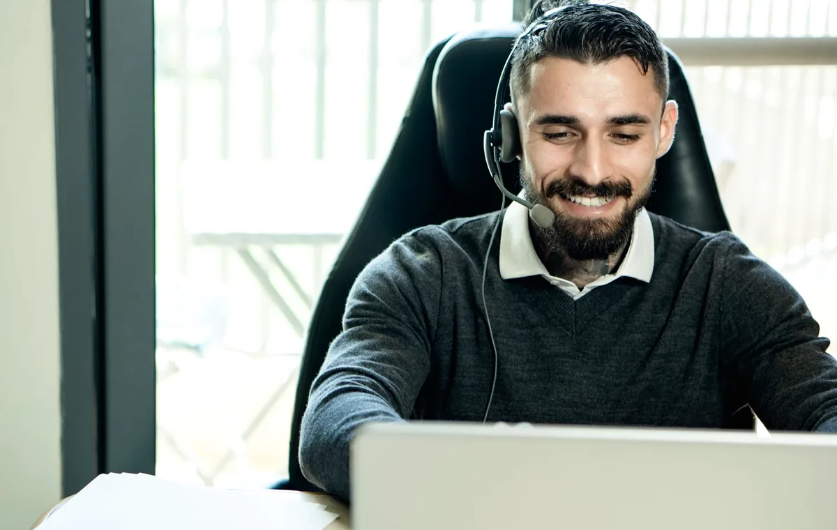 Support professional wearing headphones while working at a desk