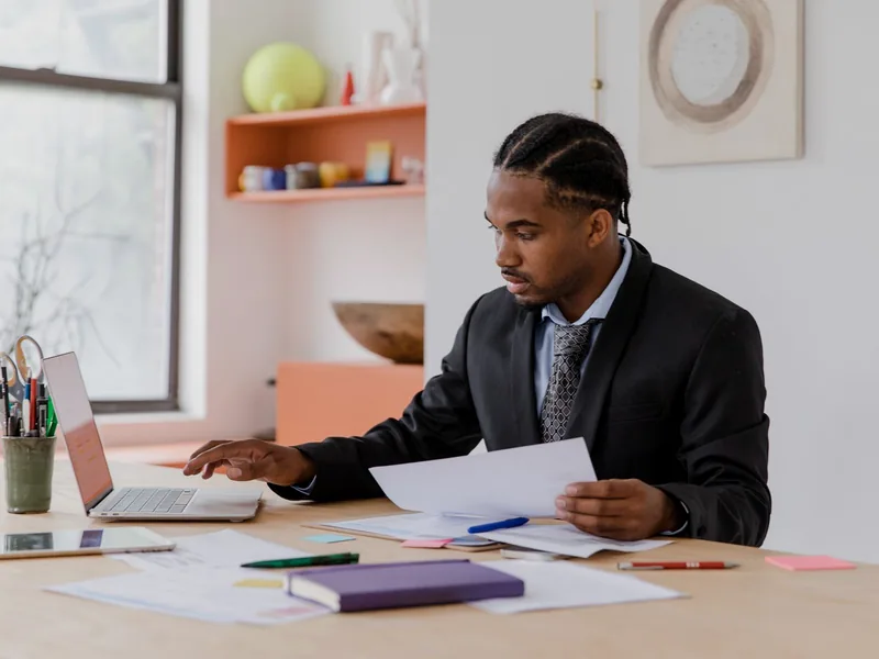 Professional working with documents and a laptop in an office