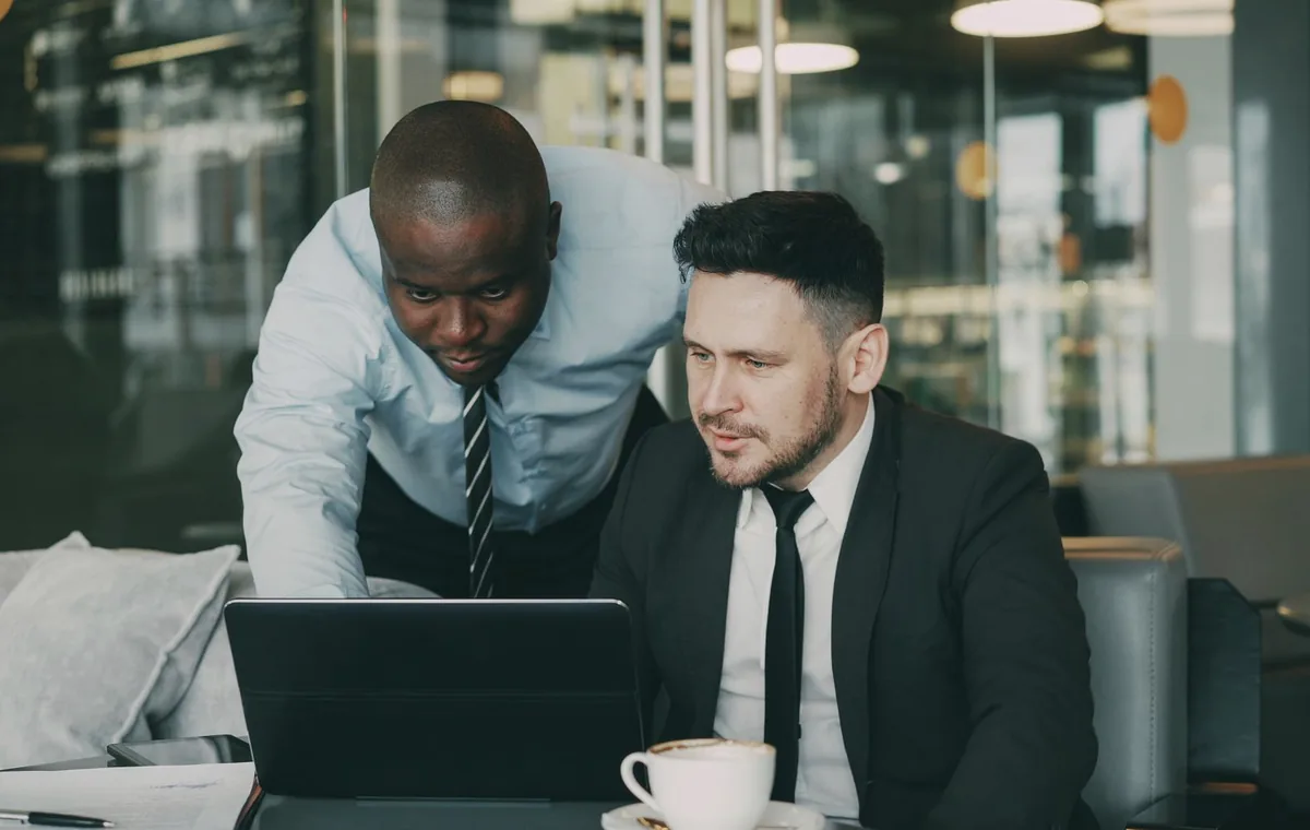 Business professionals collaborating on a laptop in a modern office