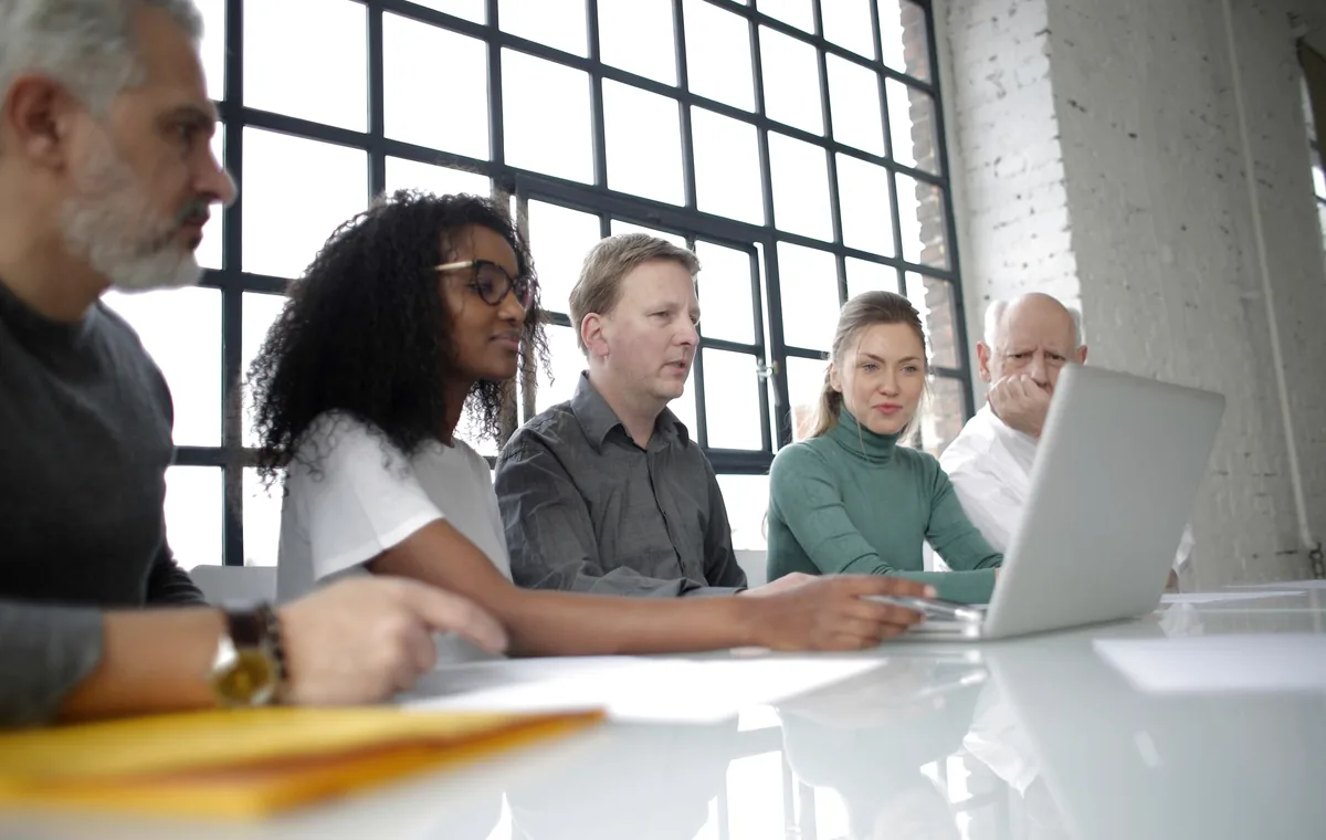 Diverse professional team reviewing work together on a laptop