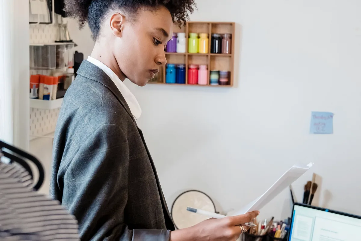 Professional reviewing documents at a desk with a laptop