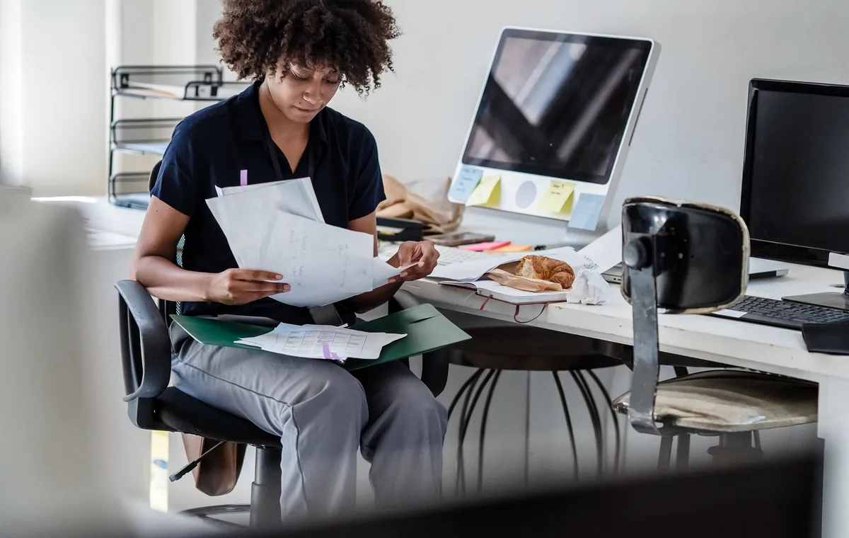 Professional reviewing documents with a laptop in a modern office